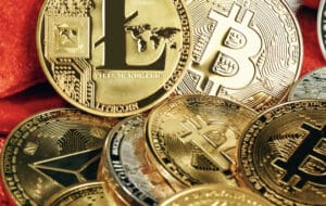 Une collection de pièces de monnaie numériques aux logos brillants de diverses cryptomonnaies, y compris Bitcoin, Ethereum, et Ripple, dispersées sur un fond sombre et numérique