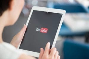 Une femme utilisant une tablette pour maximiser les vues sur YouTube.